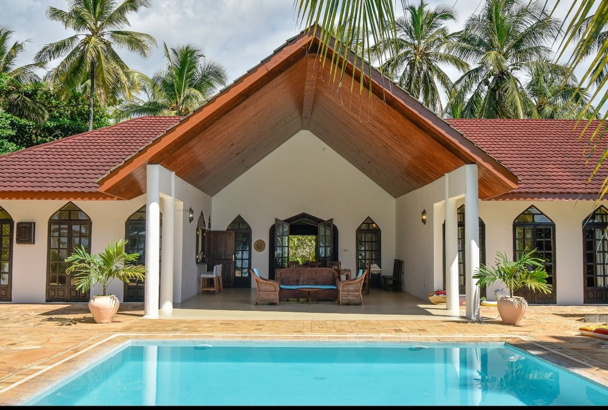 Villa exterior — full facade with open pavilion and pool